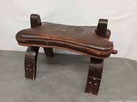 three-quarter view showing embossed leather seat and leg construction