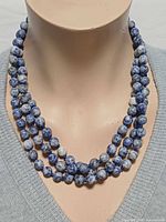 Necklace worn tripled on mannequin showing bead colour and length