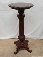 Front view of entire pedestal stand showing round top, column, and feet