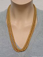 Necklace worn on mannequin showing double strands and gold tone
