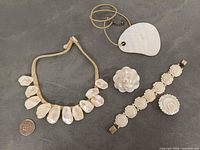 Group shot showing all four jewelry pieces with coin for scale