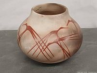 Front view of signed Native American pottery vase showing painted bird motif