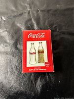 Front of original Coca-Cola box showing bottle salt & pepper shakers image