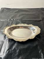 Top view of silver-plated oval dish showing rim design and inscription