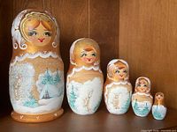 All five nesting dolls lined up by size