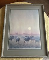Framed Robert Bateman print showing wildebeest scene and sun, full view including frame and matting