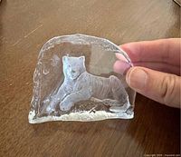 Front view of clear crystal paperweight showing frosted intaglio tiger