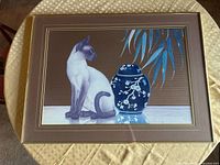 Full view of framed artwork showing cat, jar, mat and frame