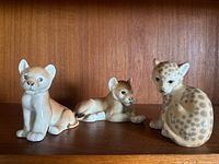 Front view of all three porcelain big cat cub figurines on shelf