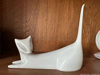 Full left-side view of white porcelain cat figurine