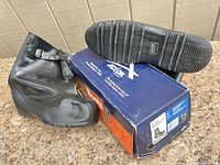 Pair of black rubber overshoes with Action box