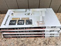 Four sealed boxes of Armstrong luxury vinyl plank flooring stacked, labels visible