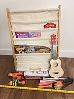 Full lot showing book rack, ukulele, musical toys, books, posters