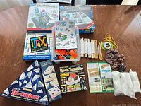 Overview of all items on table including boxed games, building pieces and rock-tumbler supplies