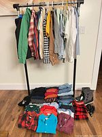 Full lot on rack and folded piles with boots and belt visible