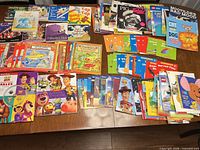 Wide view of entire lot spread on table showing Toy Story books, guided science readers, assorted board/picture books