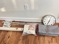 All items grouped: four rods with hardware, gray panels, packaged bedspread accessory, silver wall clock