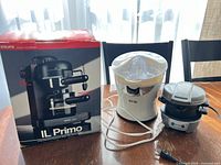 Boxed Krups espresso maker, Citri·Star juicer and compact press on table