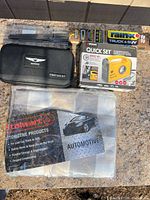 All four items grouped: Genesis first aid kit, Quick Set inflator box, sealed Bosch wiper blade, sunshade in bag