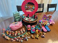 Wide view showing all playsets, dolls, furniture and accessories on table