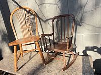 Two wooden Windsor chairs on countertop, one dining chair and one child’s rocking chair