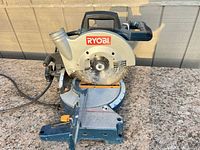 Front view of Ryobi TS1354 miter saw showing blade, base, cord, and overall wear