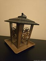 Front angle view of square bird feeder showing roof, side panels, and tray