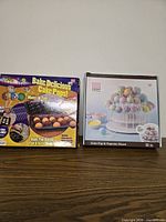 Front of Bake Pop baking pan & Sweet Creations stand boxes