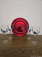 Group of four goblets and one charger displayed together