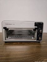 Front view showing Hamilton Beach Toastation toaster oven with glass door and control panel