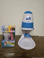 Ice shaver with box of cups and straws