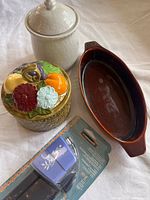 Group shot of all four items: fruit-lid jar, white jar, TG Green dish, packaged Fiskars punch