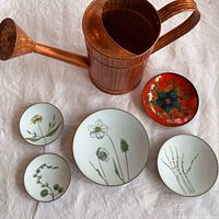 Overview of watering can and five enamel dishes