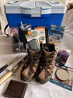 Group shot showing cooler, boots, utensils, wallet, lamp, travel gear packages, spider lights