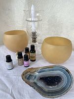 group shot showing all items: beeswax holders, crystal candle holder, essential oils, agate geode
