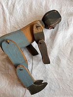 Blue-painted articulated wooden folk figure side view