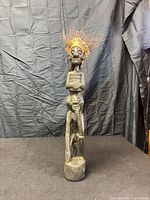 Full frontal view of carved wooden figurine showing overall design and hair