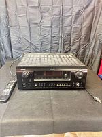 Front view of Denon AVR-889 receiver with remote and power cord