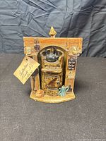 Front view of ceramic stove figurine showing all attached miniature accessories