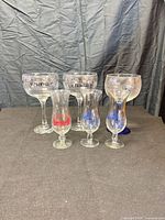 Group shot of all six souvenir glasses showing sizes and logos