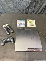 PS3 Slim console, DualShock controller, two Move controllers, two game cases