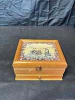 Closed wood jewelry box exterior with tapestry inlay