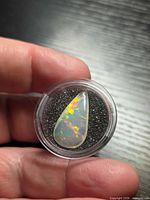 Opal in capsule showing pear shape and play of colour