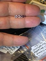 Four matching pastel pink-purple spinel gemstones lined on fingertip