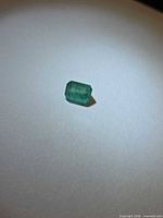 Octagon-cut green emerald on white background