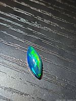 Marquise cabochon Ethiopian black opal on table surface