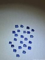 Group of 21 square blue sapphires on white background