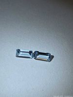 Two rectangular light blue aquamarine stones side by side