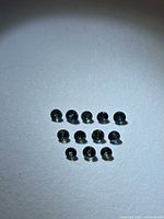 Twelve round multicolored sapphires arranged on white background