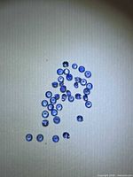 Group of small round blue sapphires on neutral background